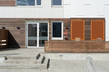 Güzel dış taş merdivenle büyük pencereler ve ahşap sundurma ile küçük şehirde yeni binasının fotoğrafı