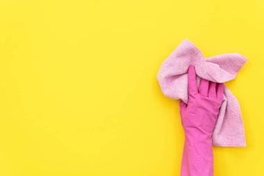 Pembe renkli lastik eldiven temizlik havlu izole metin için boş yer sarı zemin üzerine onun elinde tutan kadın