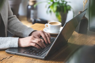 Co çalışma alanı içinde oturan ve onu laptop çalışma tanınmaz Bayan kişinin fotoğrafını yakın kırpılmış