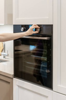 Kadın el tuning programı yerleşik fırında siyah beyaz mutfak dolap için kontrol paneli üzerinde dikey fotoğraf