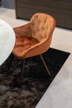 Yumuşak sandalyenin oturma odası iç koyu kahverengi halı üzerinde turuncu renk Tekstil duran yapılan dikey fotoğraf