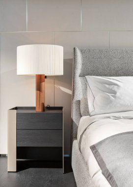 Battaniye ve yatak odası iç başucundaki lambalı beyaz yastık yatak dikey fotoğraf