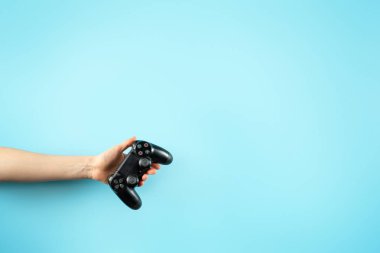 Açık mavi arka planda izole elleri siyah joystick