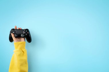  Pastel mavi arka planda izole ellerde siyah joystick