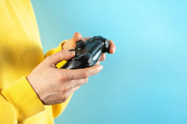 Jovem segurando joystick preto em suas mãos — Fotografia de Stock