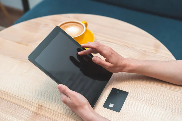 Woman sitting in cafe and using digital tablet and credit card — Stock Photo, Image