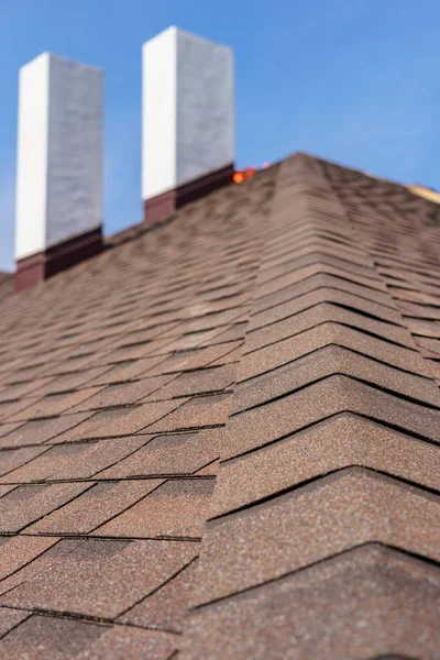 Asphalt tile roof with chimney on new home under construction — Stock Photo, Image