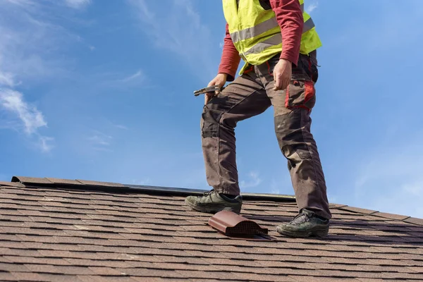 Trabajador de pie en el techo de baldosas de nuevo hogar en construcción — Foto de Stock