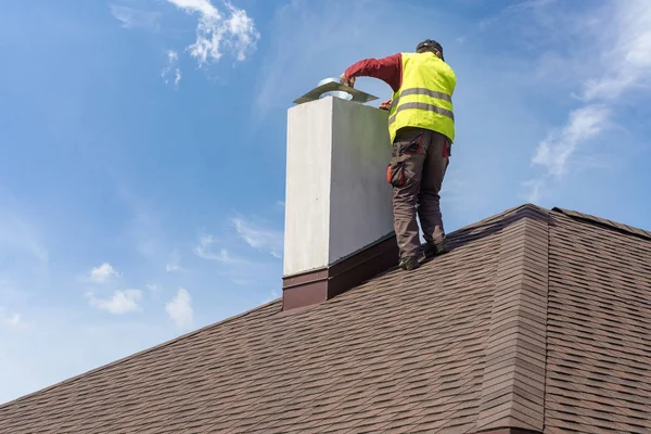 Man install chimney on roof top of new house under construction — Stock Photo, Image