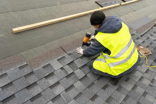 Arbeiter mit pneumatischer Nagelpistole installieren Ziegel auf dem Dach des neuen hou — Stockfoto