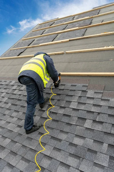 Workman met pneumatische Nagelpistool installatie tegel op dak van nieuwe hou — Stockfoto