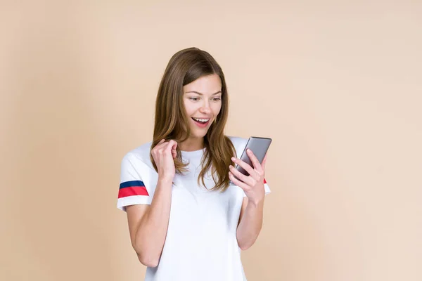 Front view of adult girl holding smartphone in hands