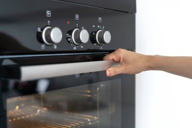 Kadın modern fırın ve açılış cam kapı inşa kolu tutarak