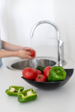 Bulanık arka planda kadın ile mutfakta sebze ile Bowl
