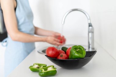 Bulanık arka planda kadın ile mutfakta sebze ile Bowl