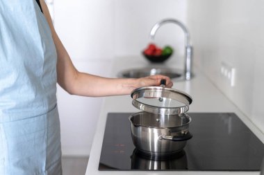 Kadın üstüne tencere ile soba inşa kullanarak, yemek pişirme