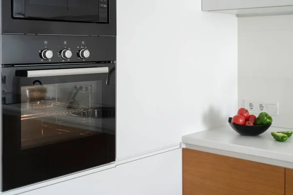 Modern built in oven with closed glass door on white kitchen