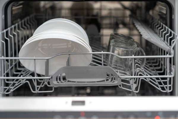 Opened modern dishwasher machine with plates and cups on kitchen — Stock Photo, Image
