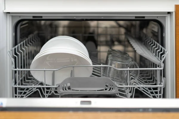 Máquina de lavar louça moderna aberta com pratos e copos na cozinha — Fotografia de Stock