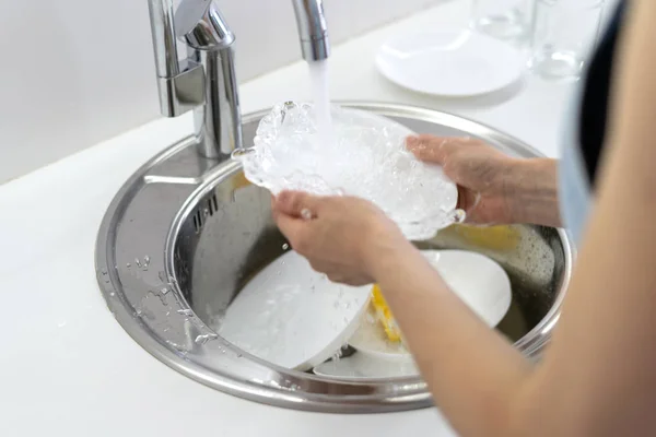 Placa de lavado de mujer en fregadero en cocina blanca — Foto de Stock