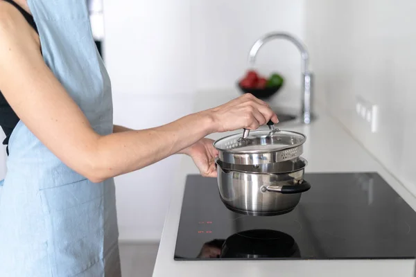 Femme utilisant poêle intégré, tenant la casserole dans les mains, cuisson des aliments — Photo