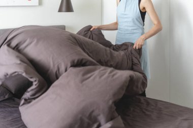 Aydınlık ve hafif yatak odası içinde yatak yapma Housemaid kadın