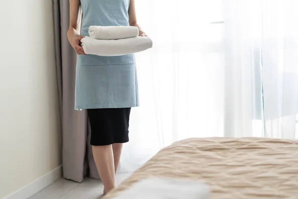 Housemaid vrouw die witte handdoeken in handen houdt — Stockfoto