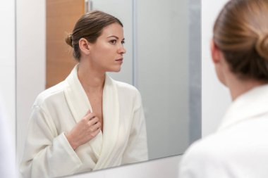 Banyoda aynaya bakan bornozkadın