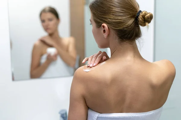 Banyoda omuza vücut kremi uygulayan kadın — Stok fotoğraf