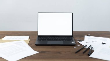 Ahşap masada modern dizüstü bilgisayar ve belgeler