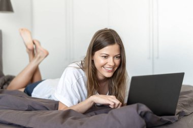 Yatakta laptop kullanarak Genç Yetişkin kadın