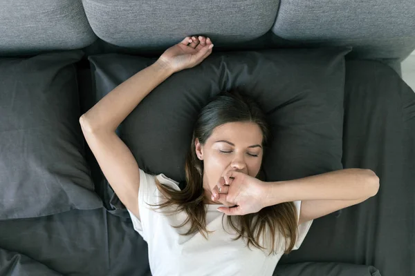 Jong volwassen vrouw slapen op bed in de ochtend — Stockfoto