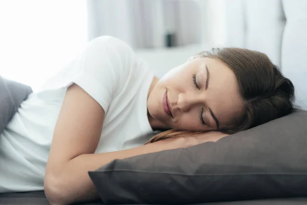 Jong volwassen vrouw slapen op bed in de ochtend — Stockfoto