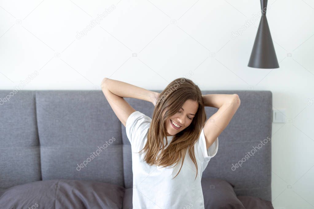 Young adult woman awaiking on bed in morning