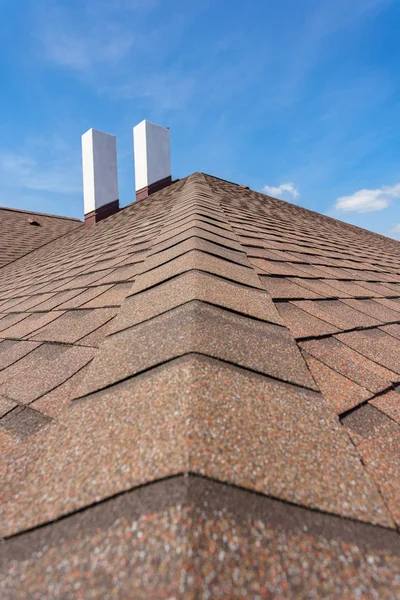 Asphalt tile roof with chimney on new home under construction — Stock Photo, Image