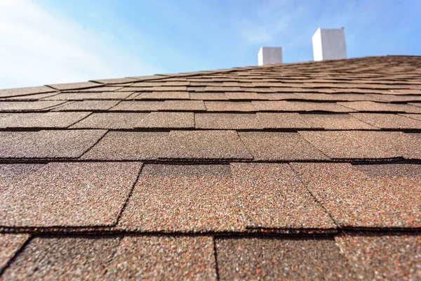 Asphalt tile roof with chimney on new home under construction — Stock Photo, Image