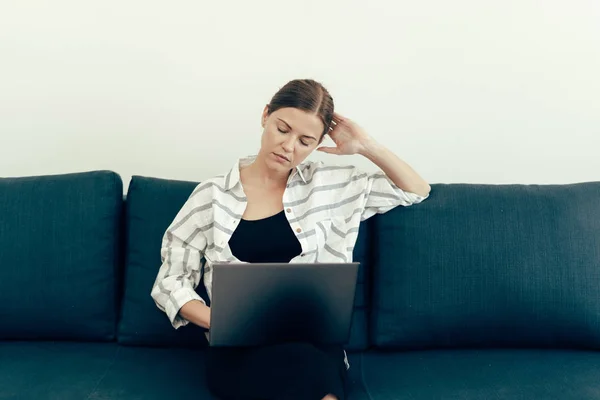 Unavená mladá dospělá žena pracující s laptopem — Stock fotografie