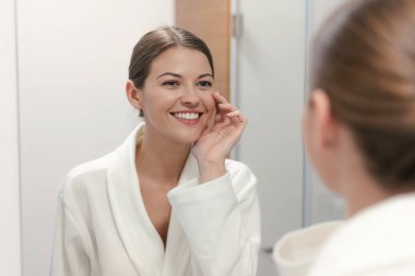 Banyoda aynaya bakan bornozkadın