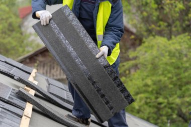 İnşaat takılan yeni evin çatısına işçi fayans monte