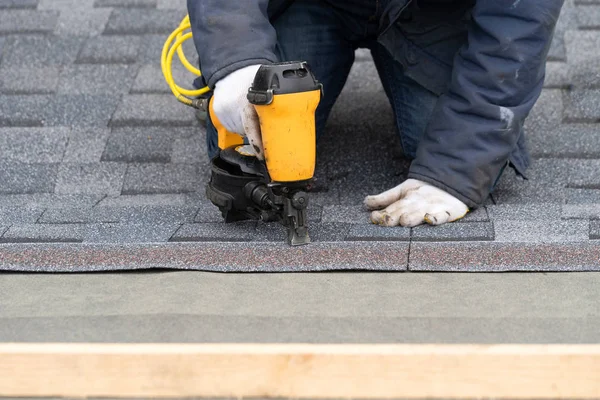 Arbeiter mit pneumatischer Nagelpistole installieren Ziegel auf dem Dach des neuen hou — Stockfoto