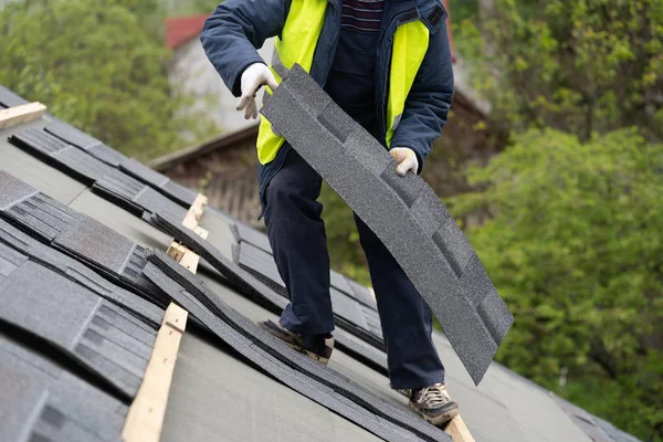 Workman install tile on roof of new house under construction — Stock Photo, Image