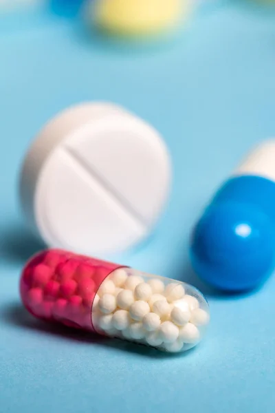 Studioaufnahme medizinischer Pillen auf blauem Hintergrund — Stockfoto