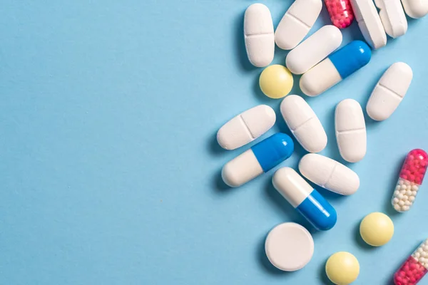 Studioaufnahme medizinischer Pillen auf blauem Hintergrund — Stockfoto