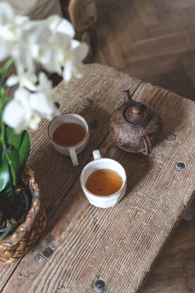 Trebord med tekanne, beger og orkide blomster – stockfoto