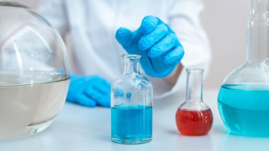 Laboratuvar analizi yapan bilim kadını ofisinde oturuyor.