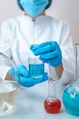 Tıbbi cam şişeyi sıvı ile tutan bilim kadını,