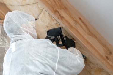 Profesyonel ustabaşı mineral kaya yünü ile termal yalıtım katmanı kuruyor