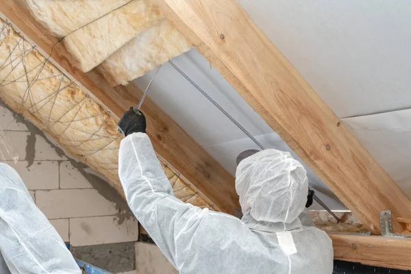 Professional roofer man installing thermal insulation layer with mineral rock wool — Stock Photo, Image