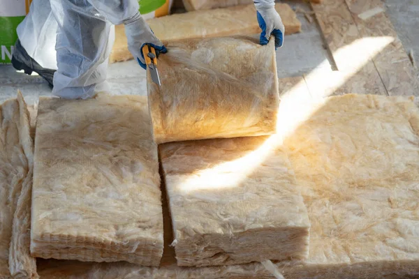 Professional foreman installing thermal insulation rock wool under the roof — Stock Photo, Image