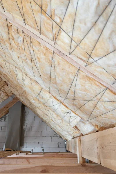 Casa em construção com lã de vidro de isolamento em um piso sótão — Fotografia de Stock